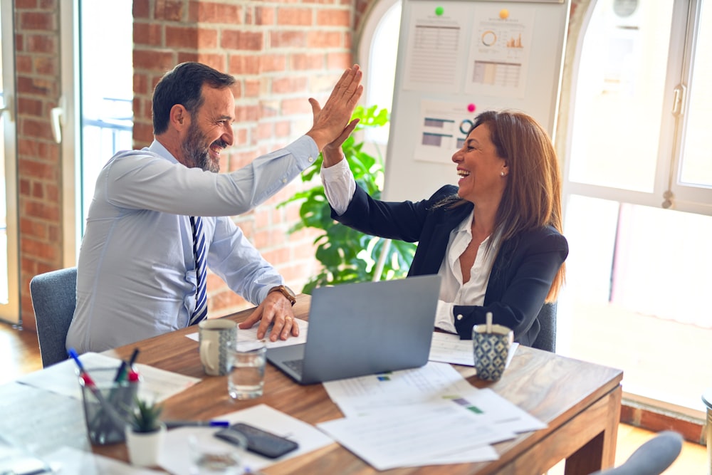 Two business colleagues celebrating a successful support outcome